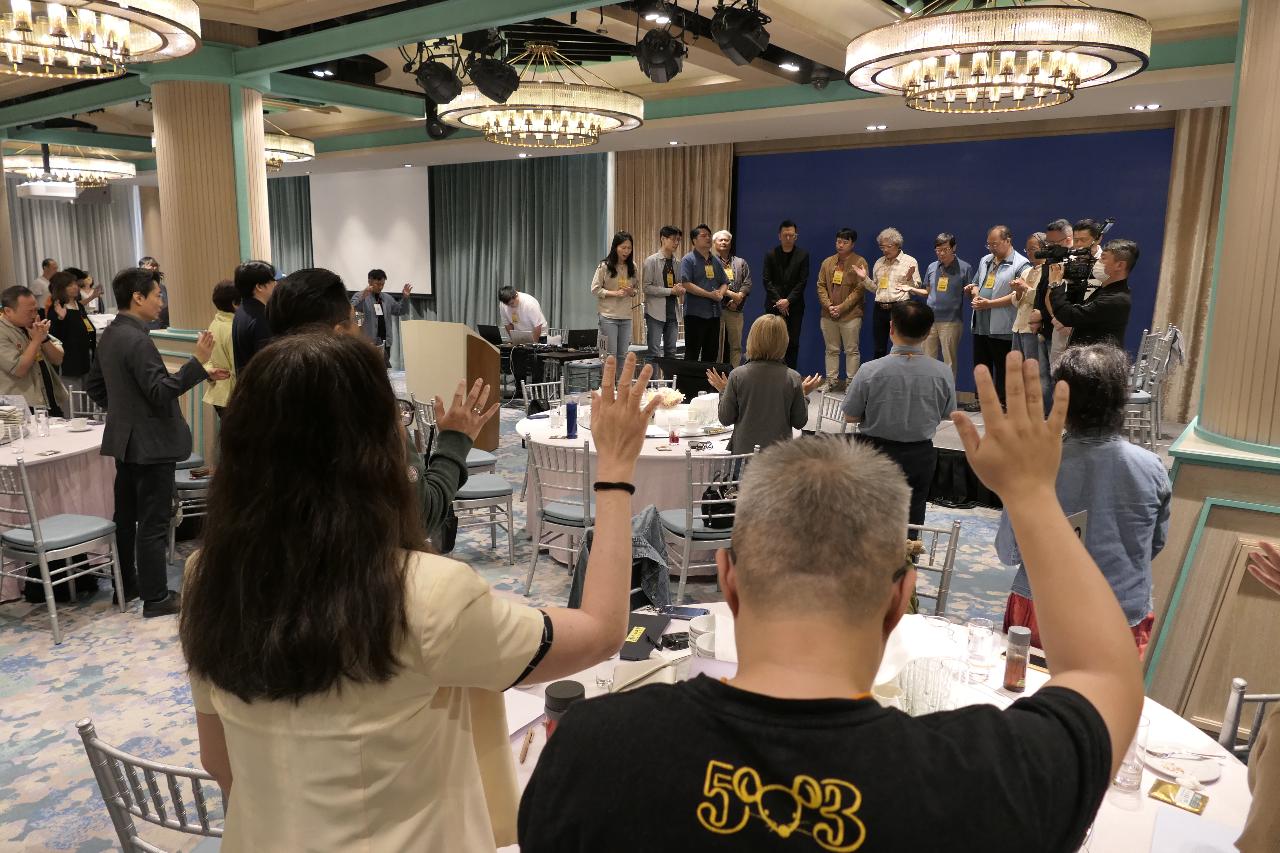 與會者為台上農業宣教團隊舉手代禱。劉以琳攝